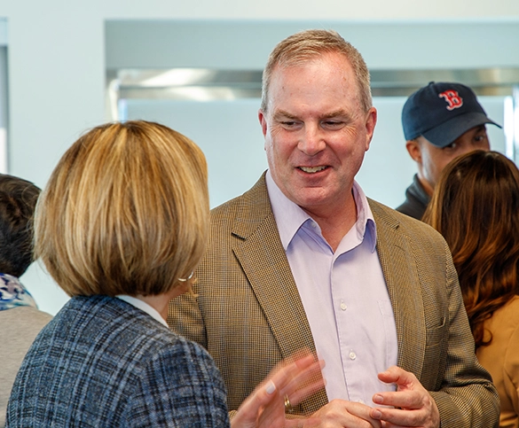 Jeff Sullivan, CEO of New Valley Bank & Trust, speaking with a woman at a professional event.