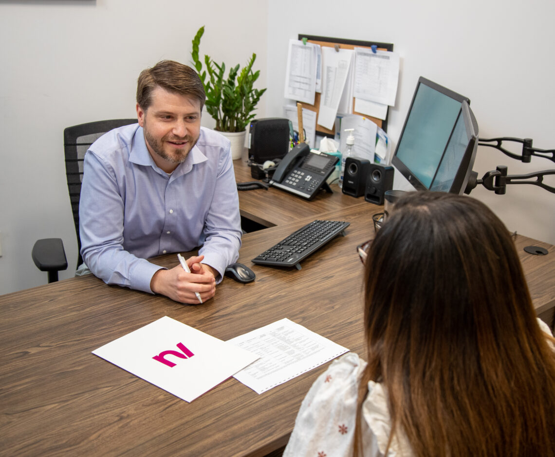 New Valley Bank employee meeting with a customer in an office setting to discuss financial services.